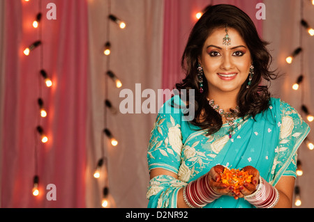 Porträt einer Braut Blütenblätter halten und Lächeln Stockfoto