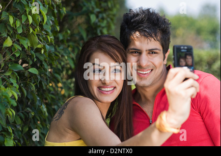 Ein paar mit dem Fotografieren von sich selbst mit einem Handy in Nahaufnahme Stockfoto
