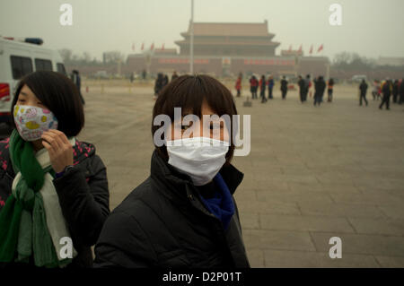 Eine Frau trägt eine Maske auf dem Tiananmen-Platz in dicker Nebel in Peking, China. 30. Januar 2013 Stockfoto