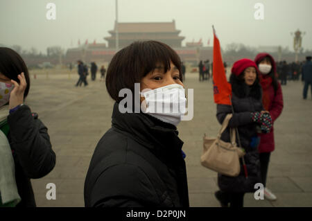 Eine Frau trägt eine Maske auf dem Tiananmen-Platz in dicker Nebel in Peking, China. 30. Januar 2013 Stockfoto