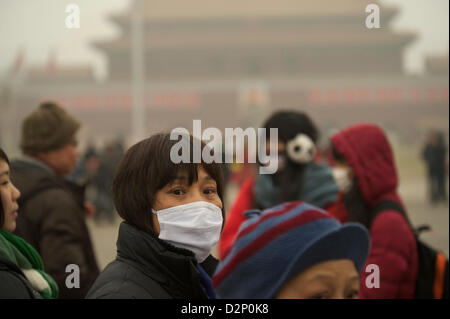 Eine Frau trägt eine Maske auf dem Tiananmen-Platz in dicker Nebel in Peking, China. 30. Januar 2013 Stockfoto