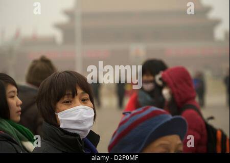 Eine Frau trägt eine Maske auf dem Tiananmen-Platz in dicker Nebel in Peking, China. 30. Januar 2013 Stockfoto