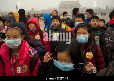 Eine Gruppe von Kindern tragen die Masken auf dem Tiananmen-Platz in dicker Nebel in Peking, China. 30. Januar 2013 Stockfoto