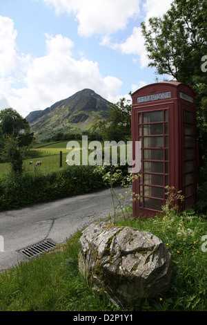 Britisches Erbe im Lake District eine alte Telefonzelle schmiegt sich in das Laub am Straßenrand Stockfoto