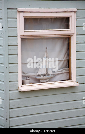 Modellyacht im Strand Hütte Fenster am Hengistbury Head, Dorset im Januar Stockfoto