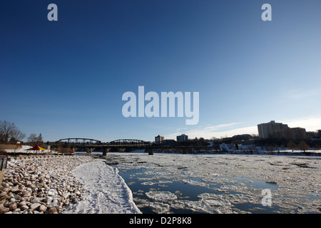 große Teile der schwimmendes Eis am South Saskatchewan River im Winter fließt durch die Innenstadt von Saskatoon Saskatchewan Kanada Stockfoto