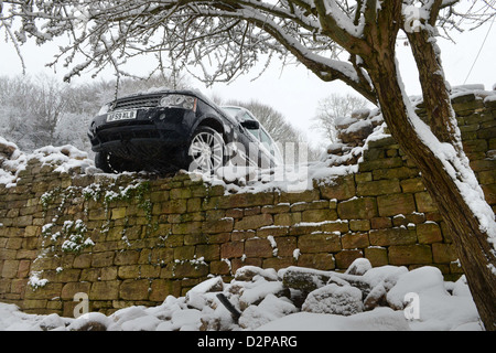 Ein Range Rover stürzte durch eine Wand nach schieben im Schnee auf einem Hügel vor Ort bekannt sind "The Ladder" in Nailsworth ne Stockfoto