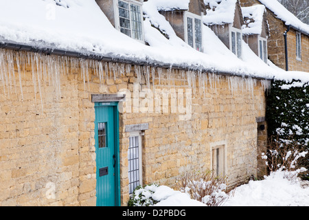 Winterschnee und Eiszapfen auf Hütten in Cotswold Dorf von Snowshill, Gloucestershire, UK Stockfoto