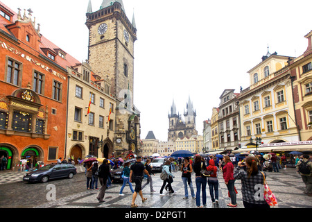 Touristen treffen sich auf dem Prager Altstädter Platz, umgeben von berühmten Wahrzeichen wie der astronomischen Uhr und der Týn-Kirche, Stockfoto