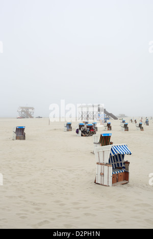 Sankt Peter-Ording, Deutschland, Strandkoerbe Stelzen im Nebel am Strand Stockfoto