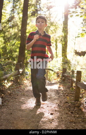 Kaukasische junge läuft Weg im Wald Stockfoto