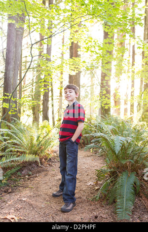 Kaukasische Junge stand auf Weg im Wald Stockfoto