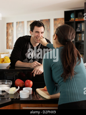 Fütterung Ehemann der Frau in der Küche Stockfoto