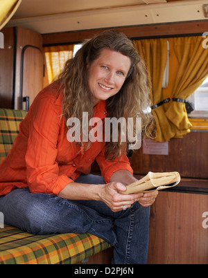 Kaukasische Frau Lesebuch im Wohnmobil Stockfoto