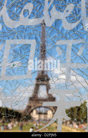 Eiffelturm gesehen durch die zersplitterte Scheibe der Wand des Friedensmonument im Parc du Champ-de-Mars Stockfoto