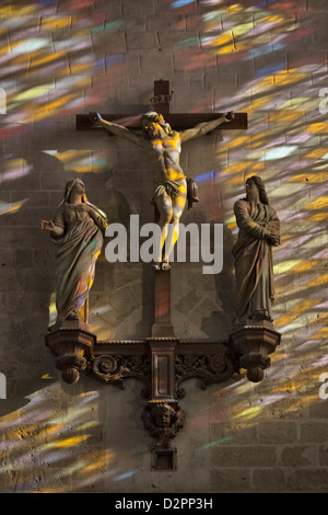 Christus am Kreuz mit Johannes & Jungfrau Maria, 1644-Statue in Stiftskirche Notre-Dame de Vernon mit Farbe aus Buntglas-Fenster Stockfoto