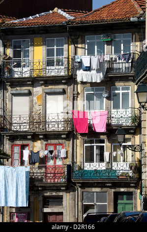 Wohnungen in einer Wohnstraße mit traditionellen schmiedeeisernen Balkonen, auswaschen hängen in der Sonne, Porto, Portugal Stockfoto