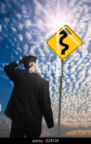 Geschäftsmann, Blick auf ein Zick-Zack-Schild Stockfoto