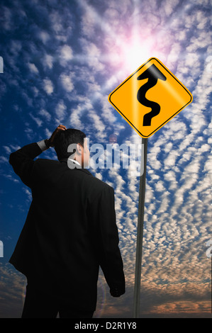 Geschäftsmann, Blick auf ein Zick-Zack-Schild Stockfoto