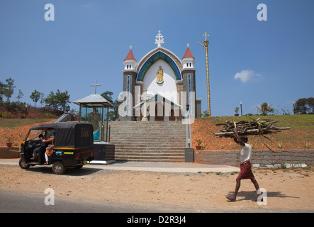 Mann mit Brennholz auf seinem Kopf, vorbei an einer Kirche in ländlichen Kerala, Indien, Asien Stockfoto