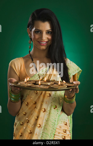 Frau hält eine traditionelle Diwali Thali lächelnd Stockfoto