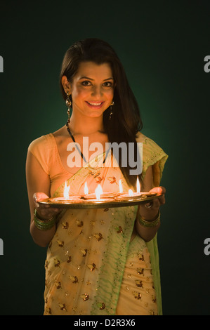 Frau hält eine traditionelle Diwali Thali lächelnd Stockfoto