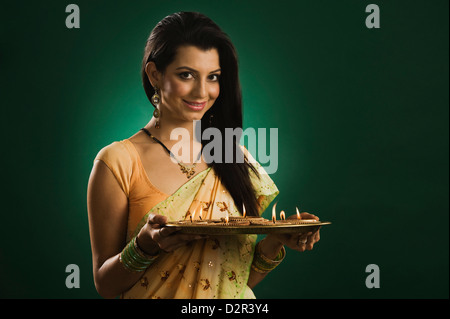 Frau hält eine traditionelle Diwali Thali lächelnd Stockfoto