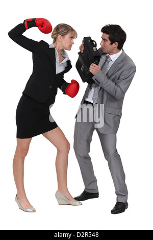 Geschäftsfrau bedrohliche männlicher Kollege mit Boxhandschuhen Stockfoto