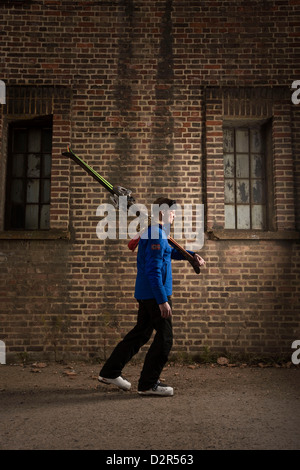 Mann zu Fuß, mit Skiern in städtischen London, aus dem Zusammenhang gerissen Stockfoto