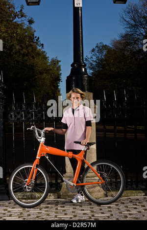 Weibliche Radfahrer steht mit Fahrrad im Park Geländer, London Stockfoto