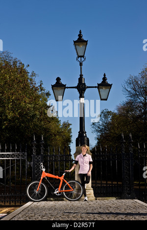 Weibliche Radfahrer steht mit Fahrrad im Park Geländer, London Stockfoto