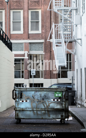 A Müllcontainer mitten in einer Großstadt-Gasse Stockfoto