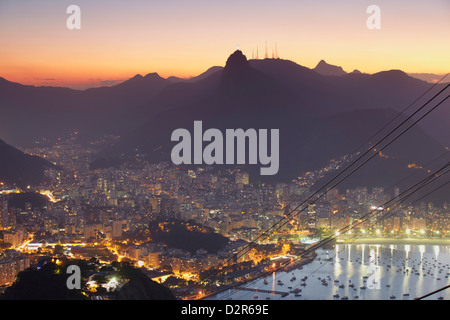 Blick auf die Christusstatue und Botafogo-Bucht bei Sonnenuntergang vom Zuckerhut in Rio De Janeiro, Brasilien, Südamerika Stockfoto