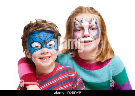 Jungen und Mädchen mit Kinderschminken Katze und Superhelden lächelnd auf weißem Hintergrund Stockfoto