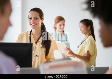 Krankenschwestern in bunten Peelings im Krankenhaus sprechen Stockfoto