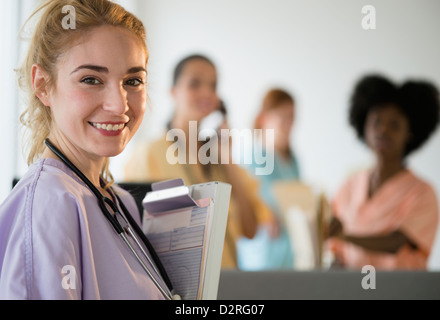 Lächelnd hält Zwischenablage im Krankenhaus Krankenschwester Stockfoto