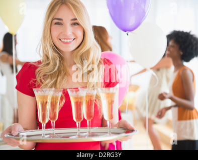 Lächelnde Frau mit Tablett Champagner Stockfoto