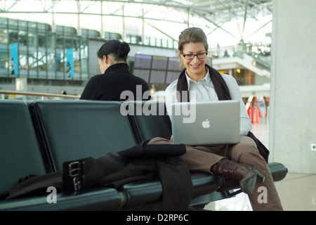 Hamburg, Germany, Business-Frau mit ihrem Macbook Pro am Flughafen Stockfoto
