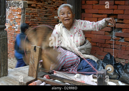 Eine Dame in Kathmandu Spinnen Wolle für die Verwendung bei der Herstellung von Kleidung und Bekleidung. Stockfoto