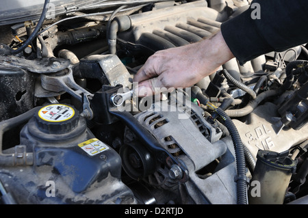 Man arbeitet an seinem Auto - anziehen von Schrauben Stockfoto