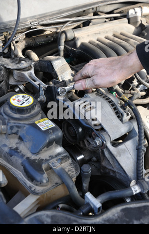 Man arbeitet an seinem Auto - anziehen von Schrauben Stockfoto