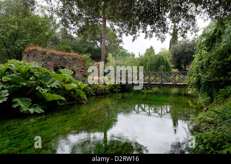 Die hölzerne Brücke Ponte Di Legno Überquerung des Flusses genannt. Garten von Ninfa. Lazio Rom. Italien Stockfoto