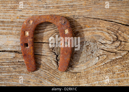 Antike Hufeisen Glück Symbol verrostet auf Vintage Holz-Hintergrund Stockfoto