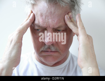 ältere Mann mit den Fingern auf seine pochende Kopfschmerzen Schmerzen Stockfoto