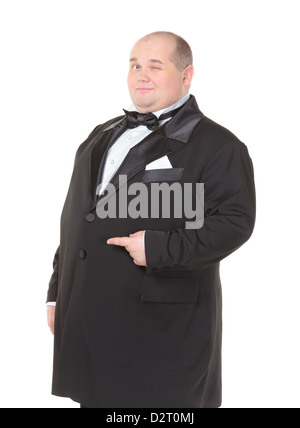 Elegante dicker Mann in einen Smoking und Fliege lächelt charmant wie er seine Hand auf die Seite gestikulieren hält Stockfoto