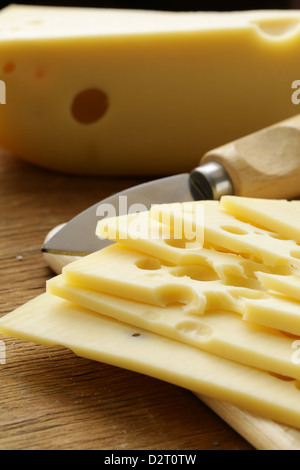 Maasdam Käse in Scheiben geschnitten auf einem Holzbrett Stockfoto