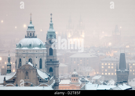 Prag - St. Nikolaus-Kirche und Türme der Altstadt bei Schneefall Stockfoto