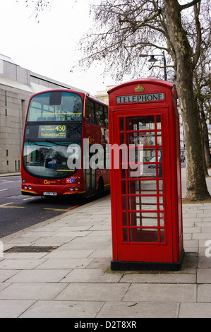 Eine typische K6 Modell London Telefonzelle vor der roten Volvo London Bus. Stockfoto