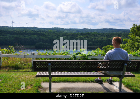 Mann auf einer Bank mit Blick auf den Cape Cod Canal, Massachusetts, USA Stockfoto