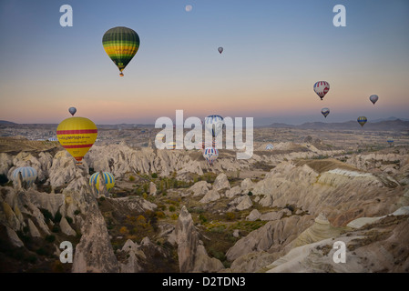 Heißluftballons über die roten Tal Kappadokien Türkei in der Morgendämmerung mit Mond Stockfoto